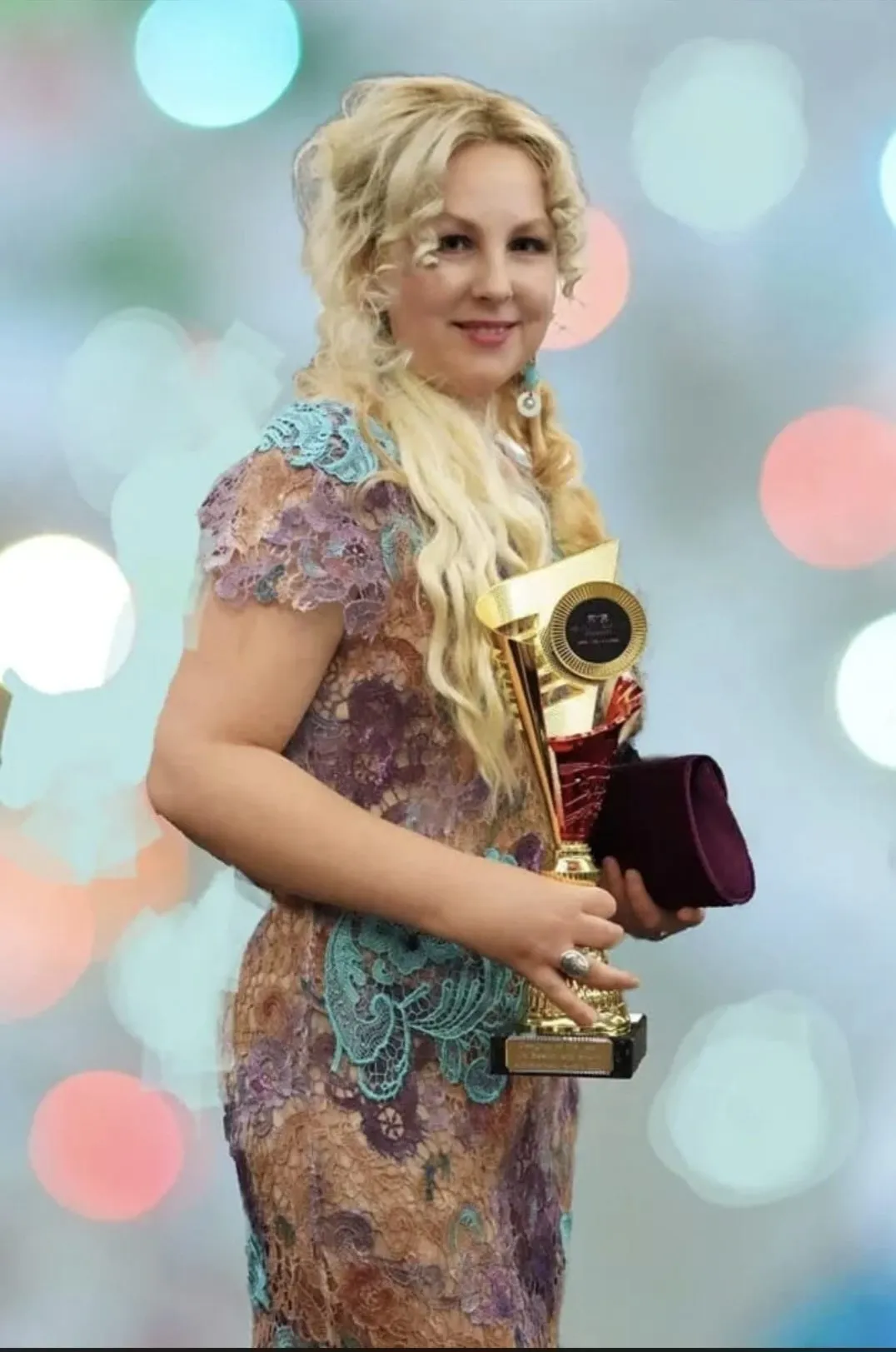 Mihaela Panaitescu holding her fashion design award